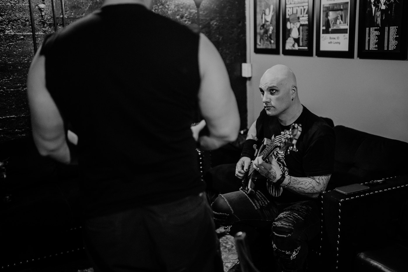Dean backstage with a guitar in his lap, working something out before a show