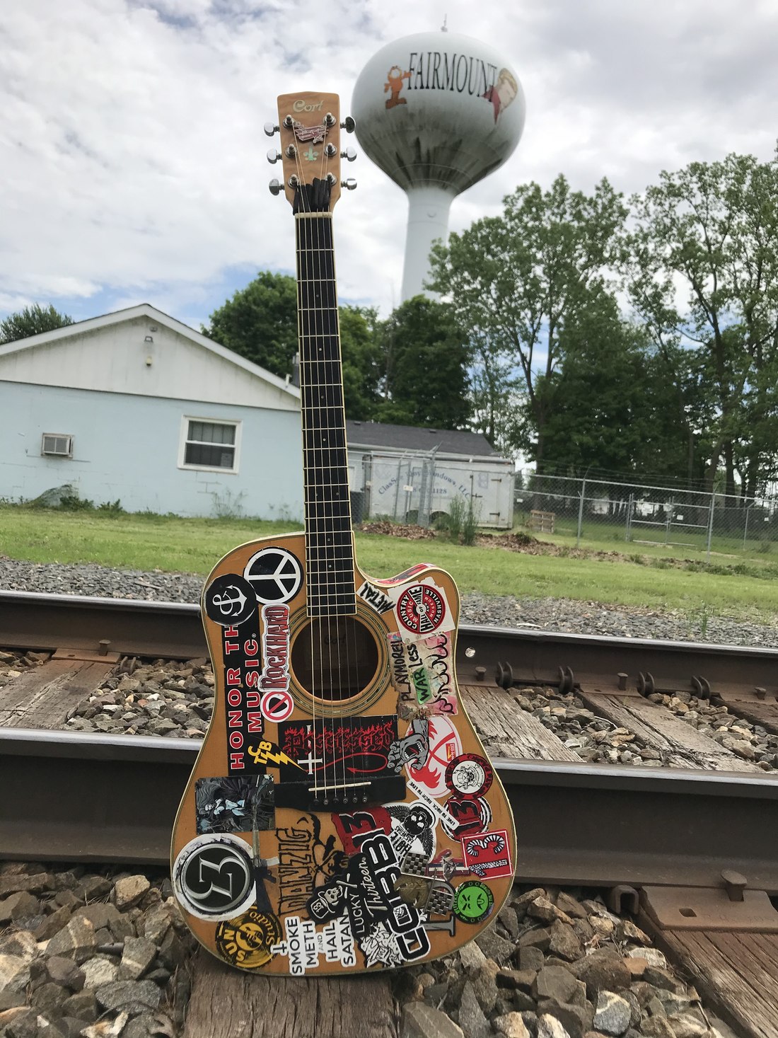 Daisy, a sticker-covered acoustic guitar propped on railroad tracks under the Fairmount water tower
