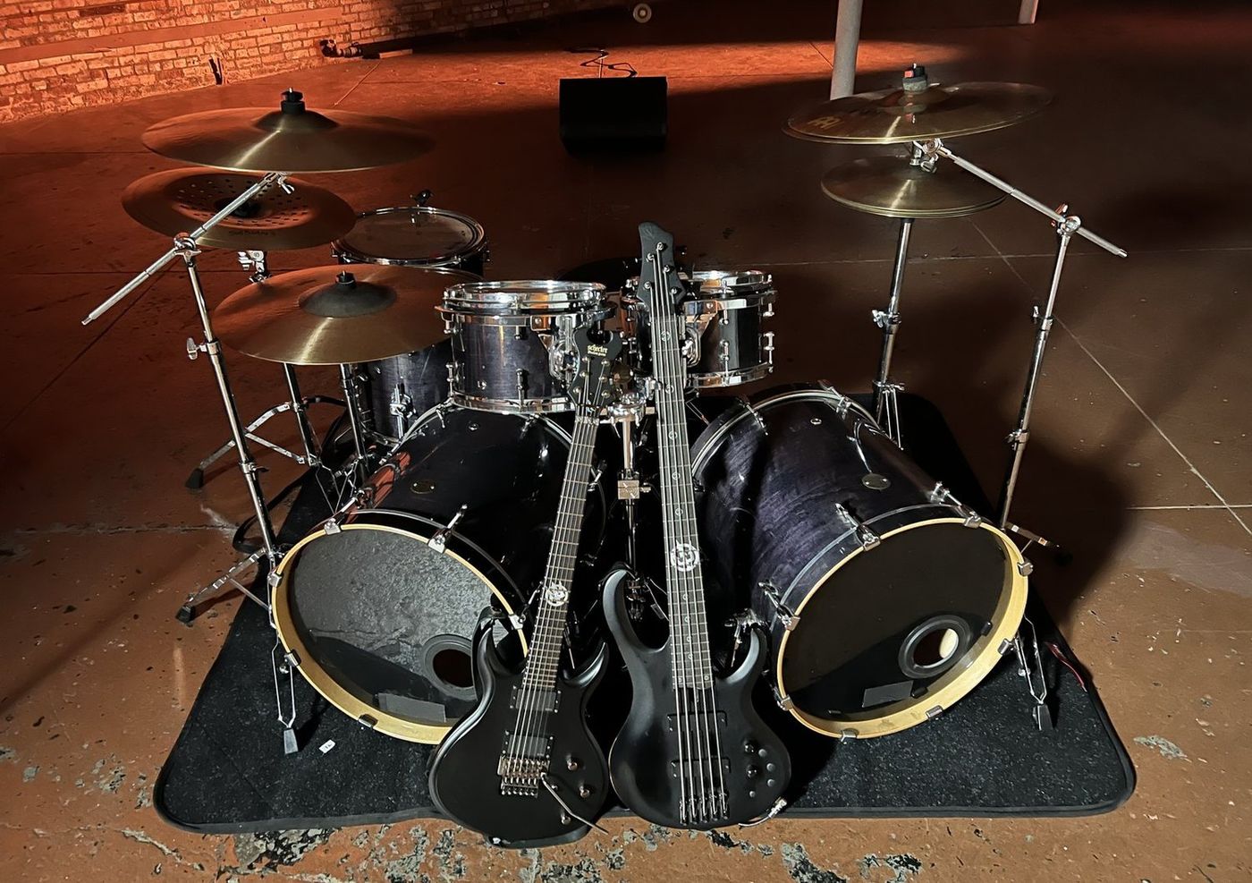 Behind the scenes on the set of Prong's The Banner video: drum kit, two guitars and a bass staged in an empty brick warehouse