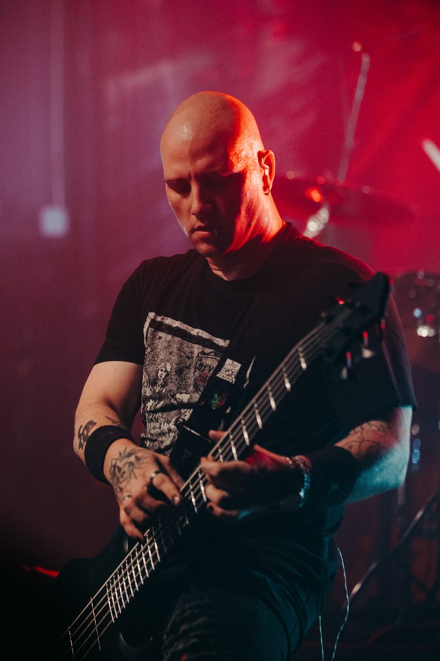 Dean playing bass under red stage light